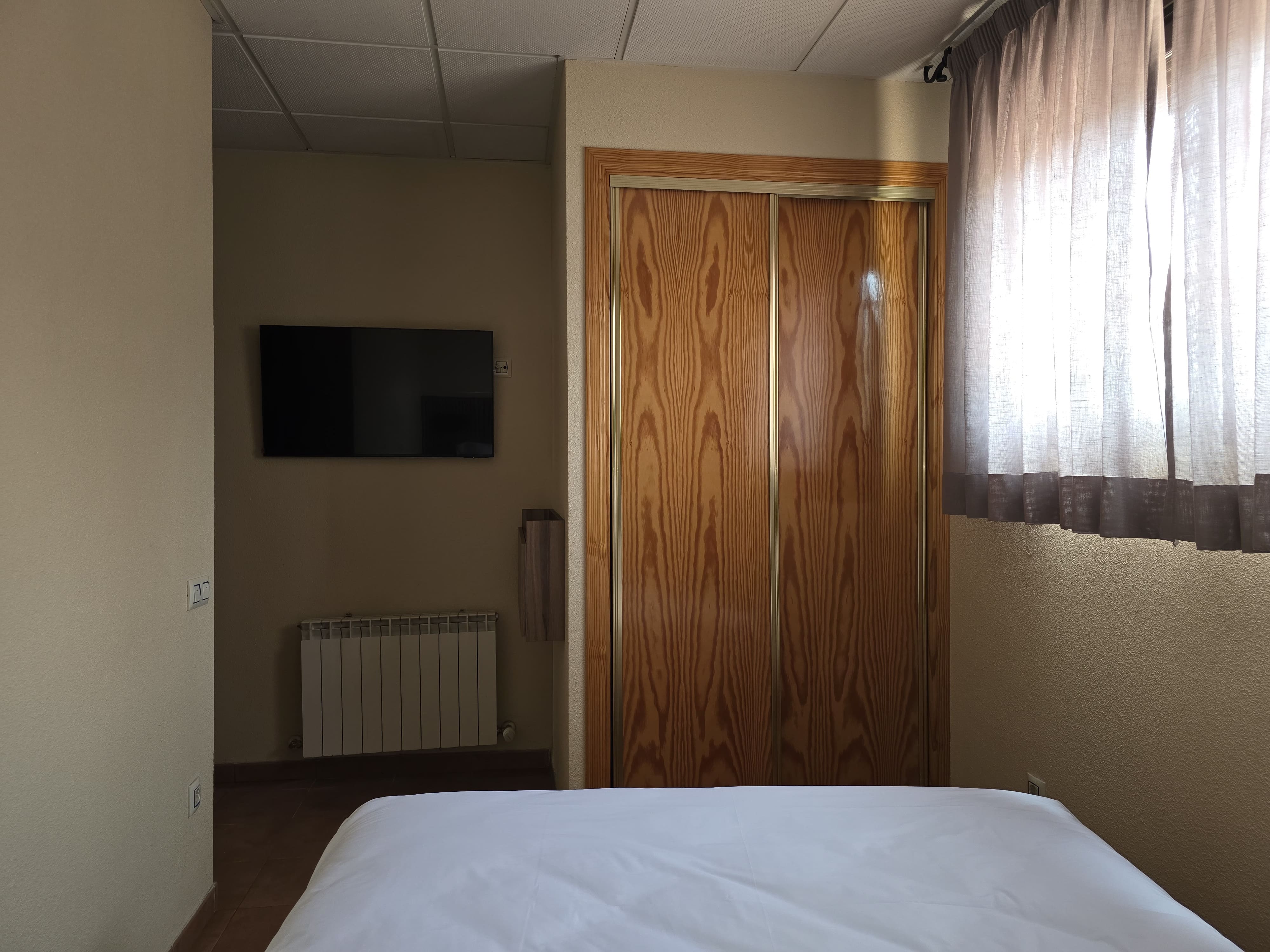 Cama matrimonial y ventana en habitación doble económica con vistas